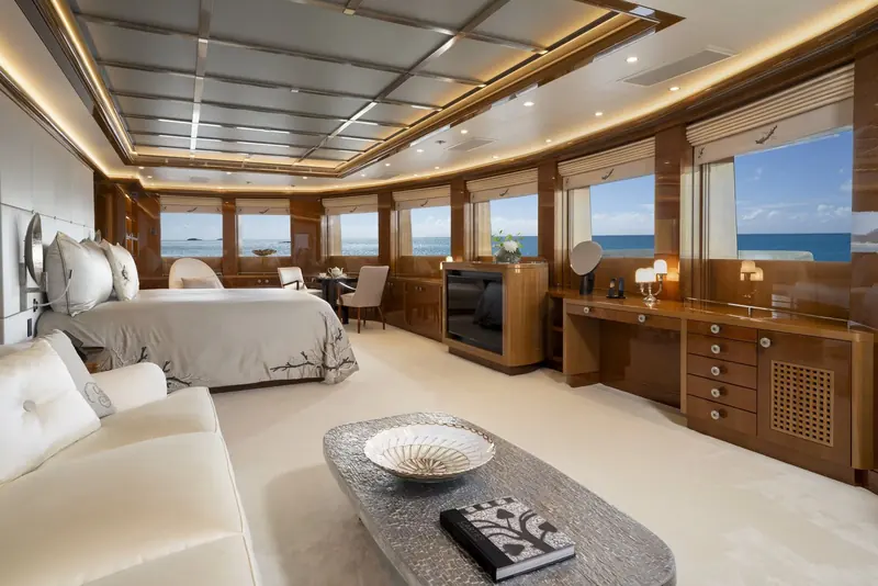 A guest suite aboard Alfa Nero, its full-beam glazing and bronzed joinery typical of Pinto's approach to a superyacht bedroom.