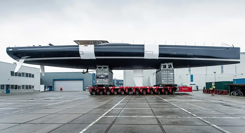 Nilaya's black hull on the quay at Royal Huisman's Vollenhove yard during rollout, showing the Reichel/Pugh-designed hull lines before launch.