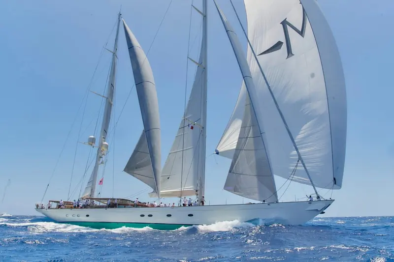 Meraki under spinnaker, her white hull and classic sheer drawn by Hoek Design around Rhoades Young's interior brief.