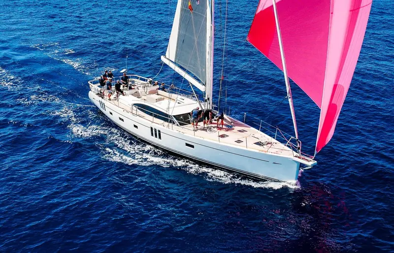 Oyster 745 Mexican Wave crewed hard under a pink spinnaker off Mallorca; naval architecture and exterior are by Humphreys Yacht Design.