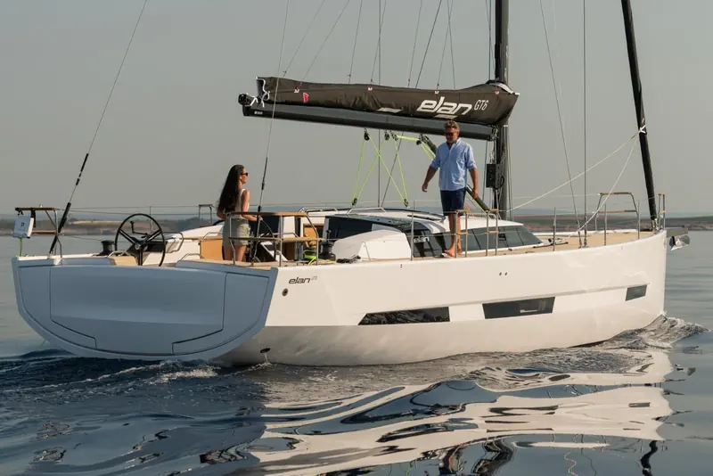 Elan GT6 heeled and driving to windward, her twin rudders and clean transom visible in the reflection.
