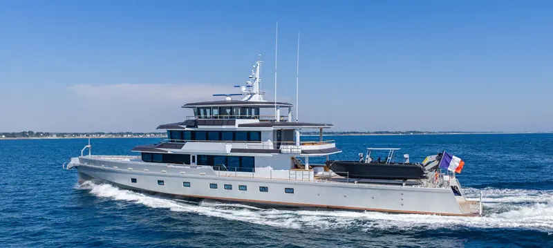 Canoa, the 49.9 metre hybrid explorer JFA Yachts delivered in 2026, underway off Brittany; hull form and naval architecture are by Humphreys Yacht Design.