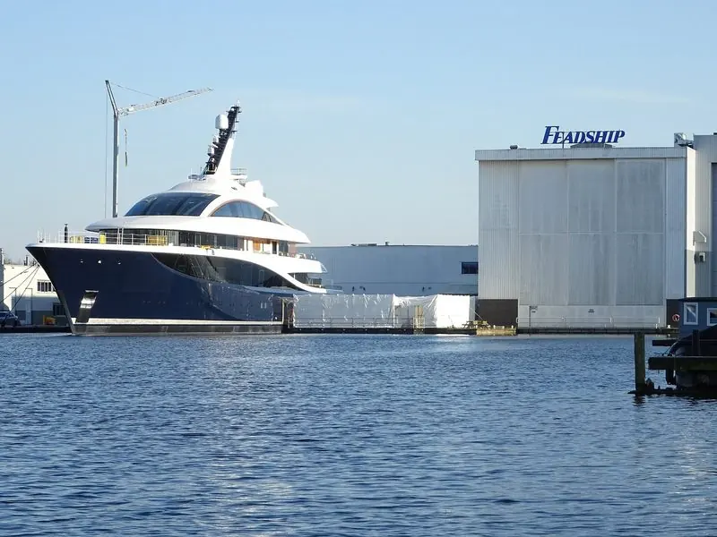 Dark blue topsides stand out against the Feadship sheds at Aalsmeer.