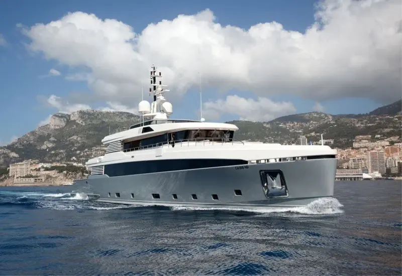 Head-on and up on the plane, the raked pilothouse glazing and vertical bow the studio drew for a shallow-draft explorer profile rather than a planing flybridge yacht.
