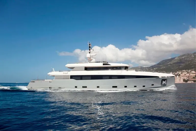 At anchor off Monaco, the broadside profile shows the run of superstructure glazing that lights the main-deck saloon along its full length.