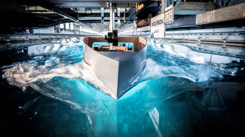 A scale hull model under test at the Wolfson Unit towing tank in Southampton, the kind of physical tank run Van Oossanen still pairs with its own computational fluid dynamics before a Fast Displacement Hull Form is cut in aluminium or steel.