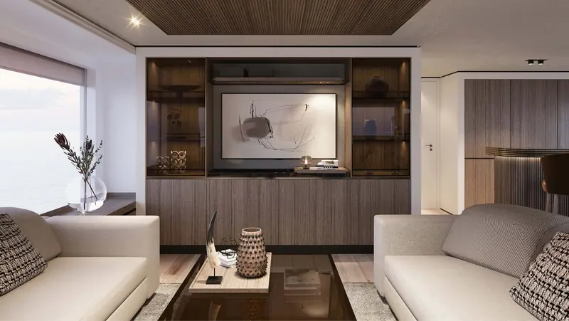 A Vripack saloon interior: wood-panelled joinery and a built-in display cabinet either side of the screen, sofas facing a window running the width of the room.