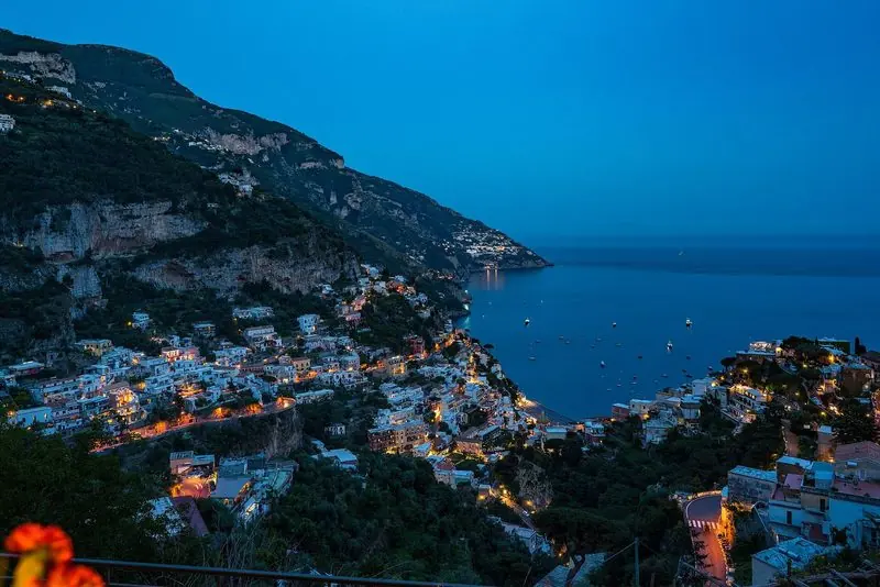 Positano at dusk, the town stacked above a shoreline with no natural harbour.