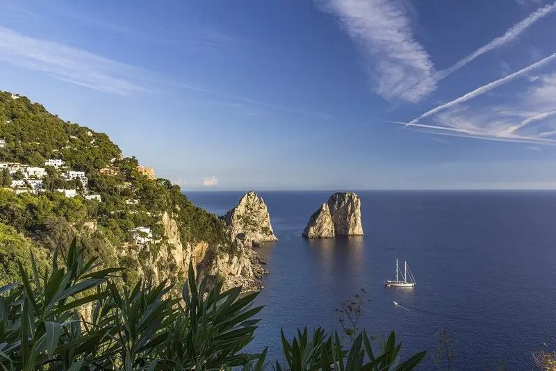 The Faraglioni off Capri, with a sailing yacht giving the scale.