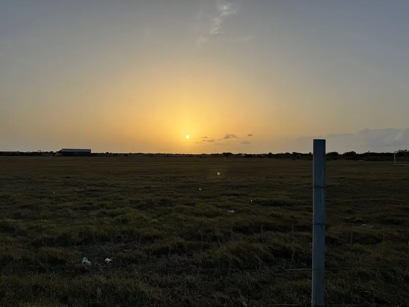 Sunset over open, low-lying ground on Barbuda, an island whose highest point is only about 125 feet, the flatness that historically made it hard to spot from seaward before running onto its reefs.
