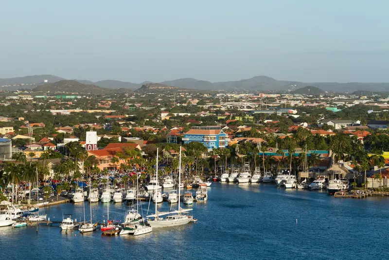 Oranjestad's inlet at Wind Creek Marina, sportfishing boats and sailboats packed gunwale to gunwale against the town's colonial rooftops.