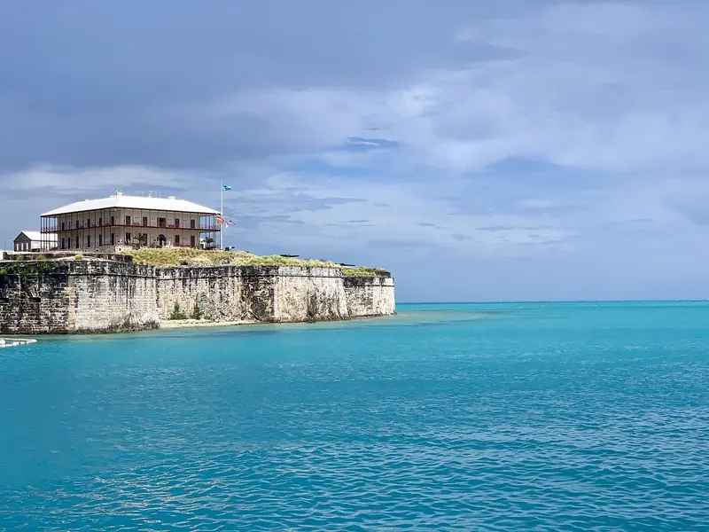 Commissioner's House and the Keep fortification at the Royal Naval Dockyard on Ireland Island, seen from the water. The restored 19th century residence now anchors the National Museum of Bermuda.