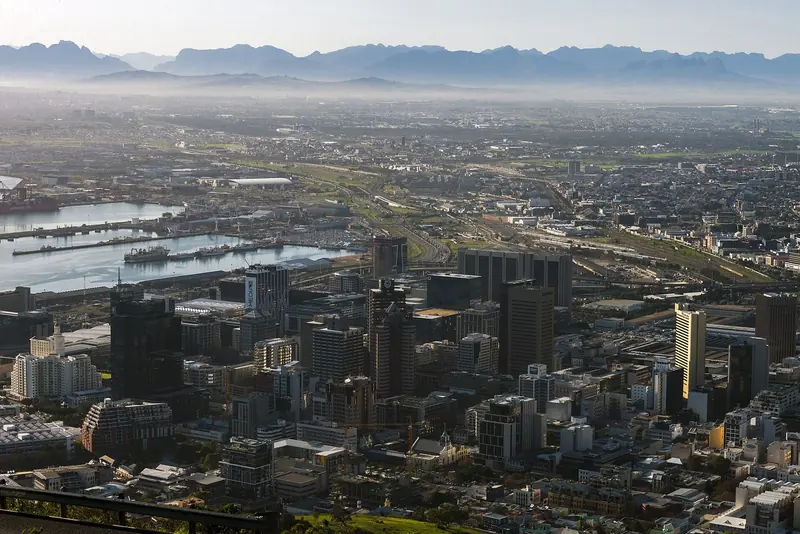 From above, the harbour basins sit hard against the city centre, with the peninsula's mountains running out behind.