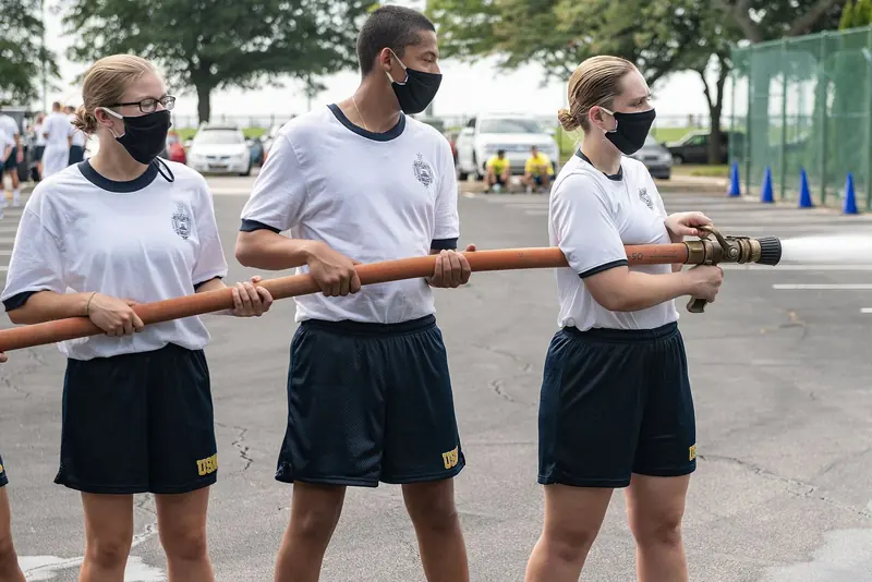 United States Naval Academy midshipmen carry an oar through Annapolis, a reminder of how much of the town's character the Academy still supplies.