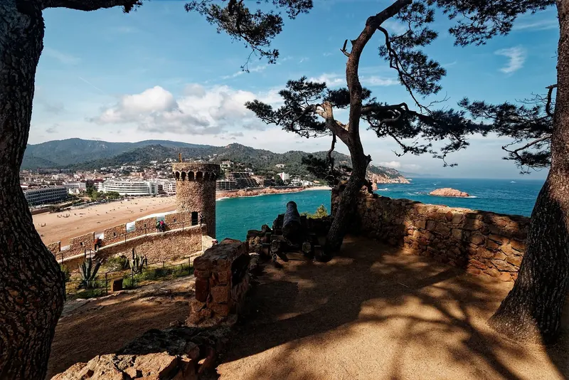 The walled old town of Tossa de Mar seen through the pines, one of the few fortified towns on a coast of coves and headlands.