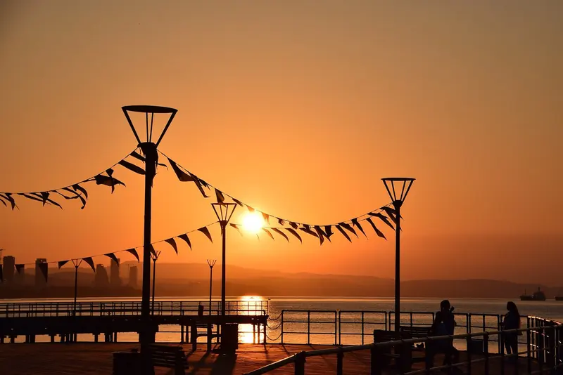 Sunrise over a Limassol pier, the kind of late-season light that keeps the water swimmable into November.