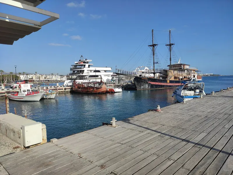 Fishing boats and a tall ship moored at Paphos Marina, a short walk from Paphos International Airport.