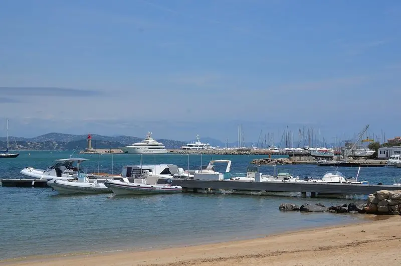 Tenders and yachts off the beach at Villefranche, where boats lie close to the shore.