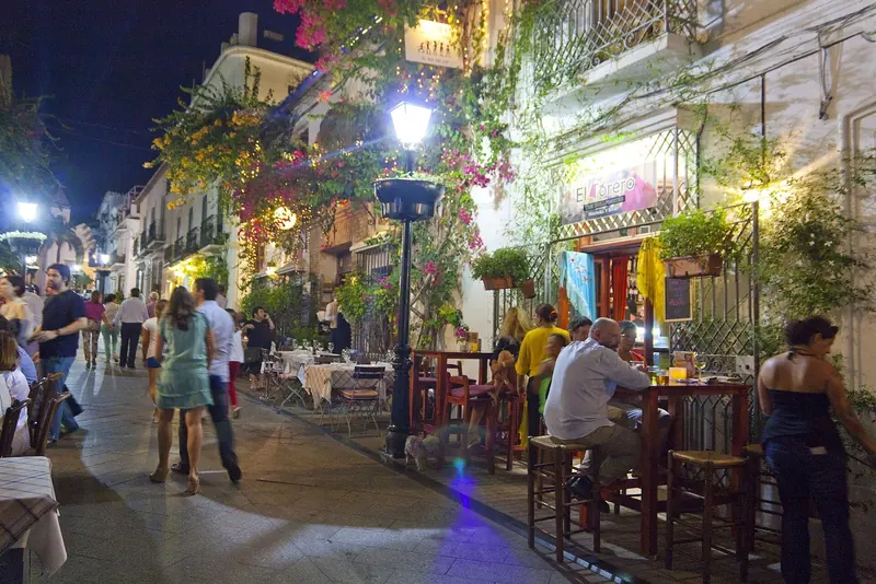 The old town of Marbella after dark, a few streets of restaurants that are the counterweight to the marina a mile down the coast.