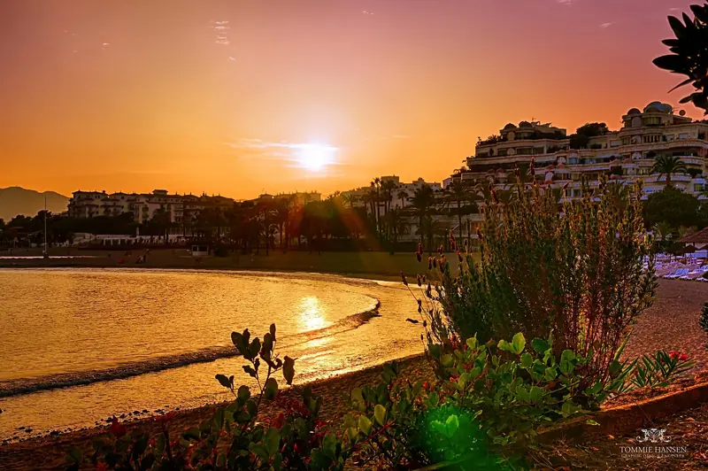 Sunset over the beach and breakwater at Marbella, on a developed coast of open roadsteads rather than anchorages.