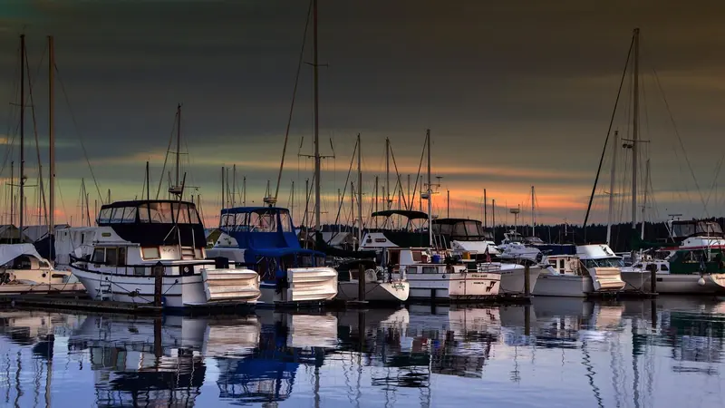 Cruising boats rafted at their slips in Ala Wai Harbor at dusk, masts bare against the trade-wind sky.