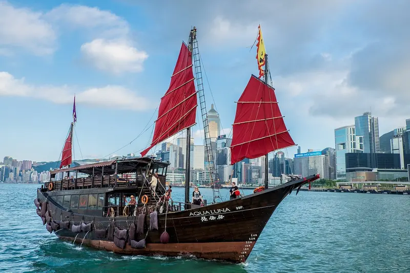 The tourist junk Aqua Luna under sail in Victoria Harbour, a reminder that most of the harbour's traditional sailing craft now work tourism rather than fishing or cargo.
