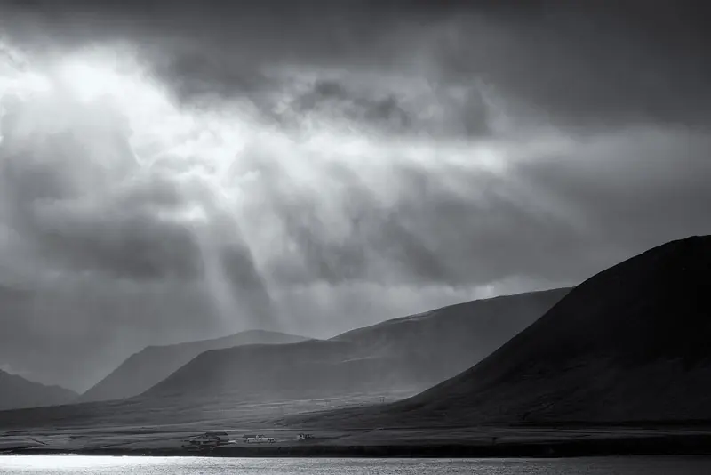 Light breaks through storm cloud over the black-sand coast near Grundarfjordur, a fishing town on the Snaefellsnes peninsula that sailing yachts use as a stop on the run around the west coast.