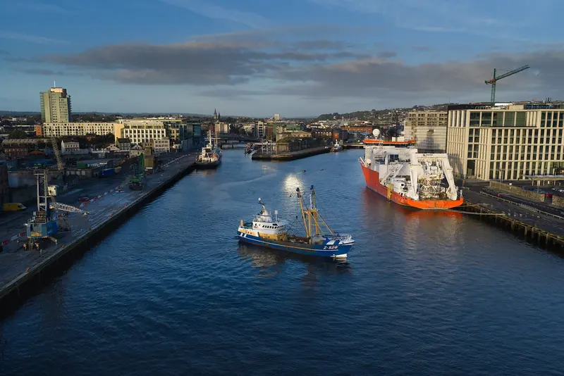 The River Lee running through Cork city into Cork Harbour, with a trawler and a survey ship working the channel