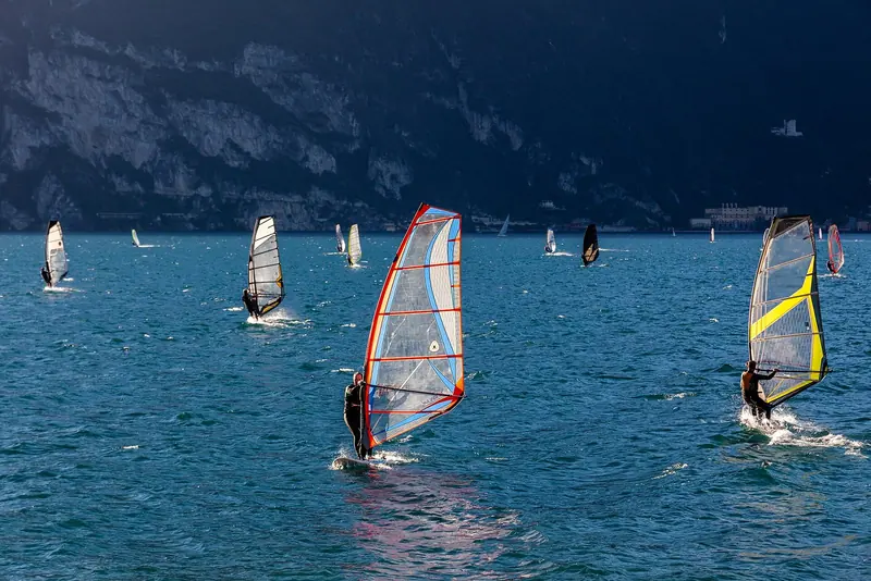 Windsurfers off Torbole, at Lake Garda's northern tip, riding the afternoon Ora wind that makes the town one of Europe's busiest wind-sports schools.