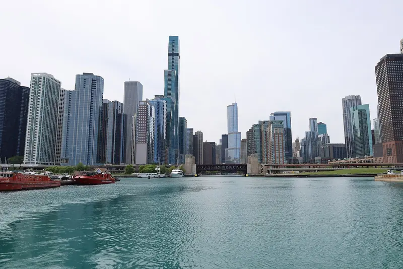 The Chicago River running into Lake Michigan through the Loop, the drawbridges a mast-up sailboat has to plan around to reach the marinas beyond.