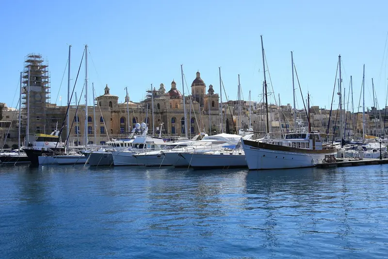 Yachts lie off the Birgu waterfront in the Grand Harbour, under the domes of the Three Cities and inside 16th century fortifications.