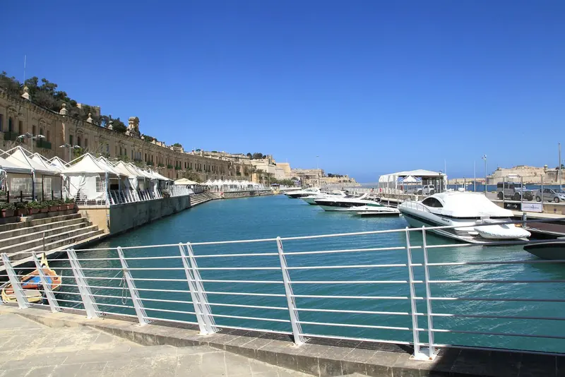 The Valletta Waterfront in Floriana, with motor yachts along the quay under the baroque warehouses of the old Grand Harbour.
