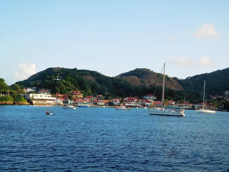 Terre-de-Haut, the main island of Les Saintes off Guadeloupe, curls around a bay dotted with yachts at anchor beneath its hillside village.