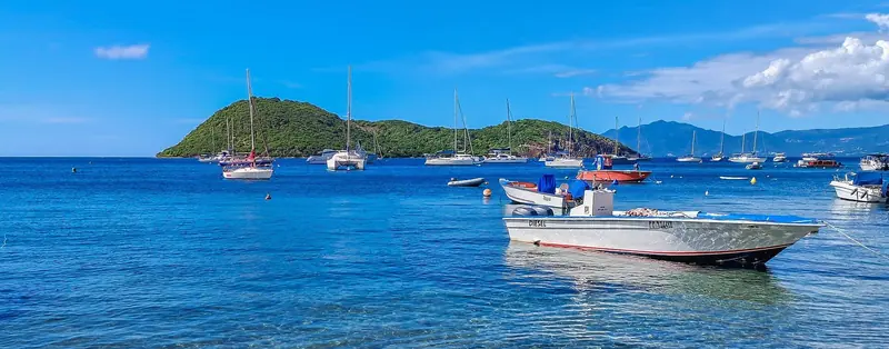 Ilet a Cabrit sits in turquoise water off Terre-de-Haut, its green slopes ringing a sheltered anchorage popular with visiting yachts.