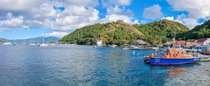 Anse du Bourg, the main anchorage at Terre-de-Haut, holds a scatter of small boats below the village's red-roofed houses.