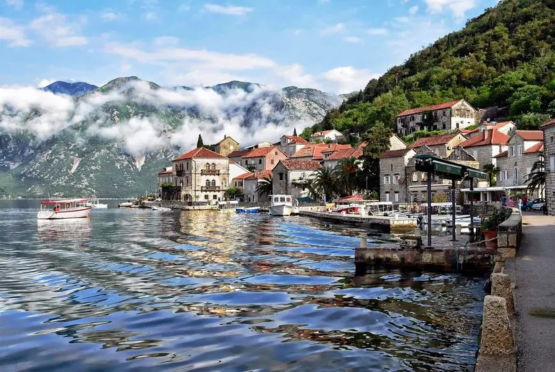 The islet church of Our Lady of the Rocks stands in open water off Perast, its quay low enough for a tender to come straight alongside.