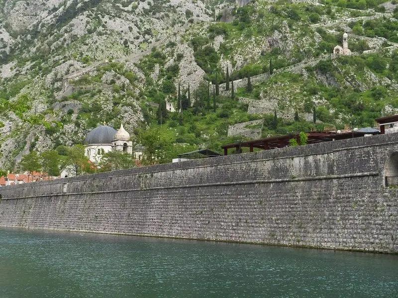 Sveti Stefan fills its own rock islet on the open coast, tied to the mainland by a causeway with a small boat lying in the lee of the point.