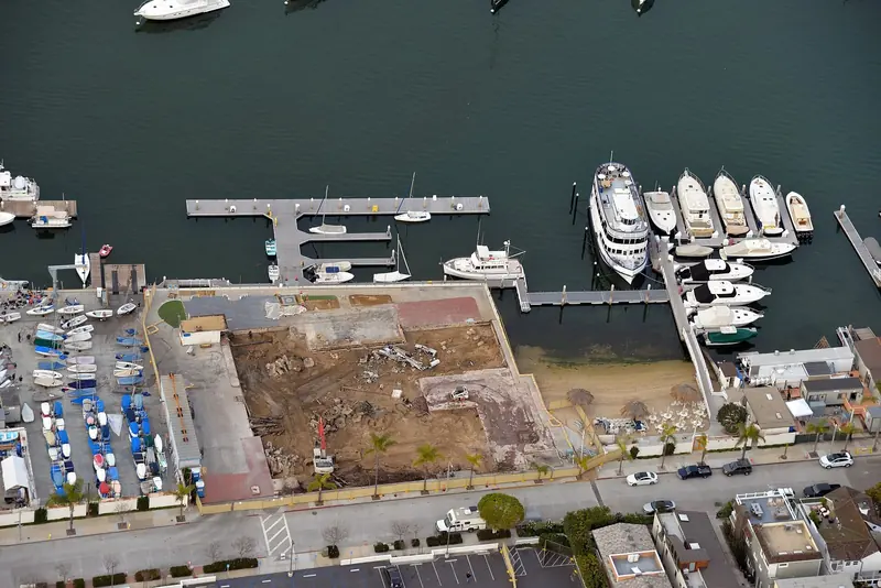 An aerial view over slips at the Newport Harbor Yacht Club, motor yachts and sailboats packed along the finger docks.