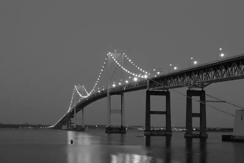 The Pell Bridge lit at dusk, marking the run home into Newport Harbor at the end of a race day.