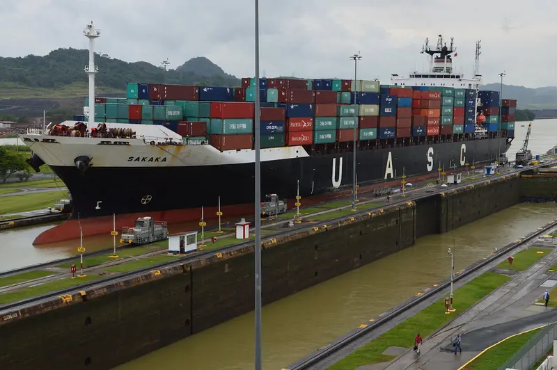 A container ship in the locks. A yacht up to 65 feet transits the same canal for a toll of about USD 1,800, frozen until 30 September 2026.