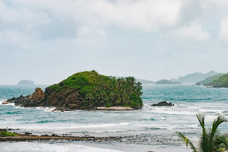 Surf breaking on a forested islet, on a Caribbean coast that runs about 200 miles east from Colon to the Colombian border.