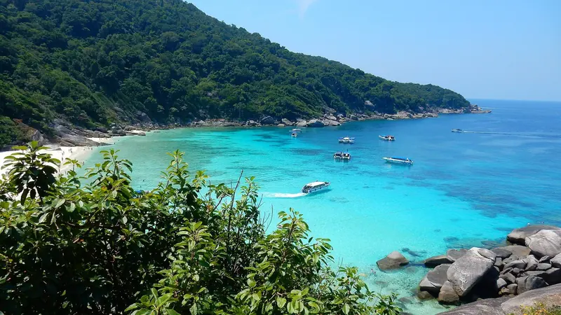 Turquoise water off a forested headland with day boats at anchor, the water that closes when the south west monsoon arrives in May.