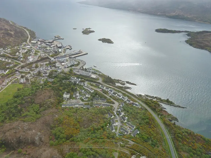 A village at the head of a sea loch from the air, showing the sheltered water and the near total absence of berthing on this coast.