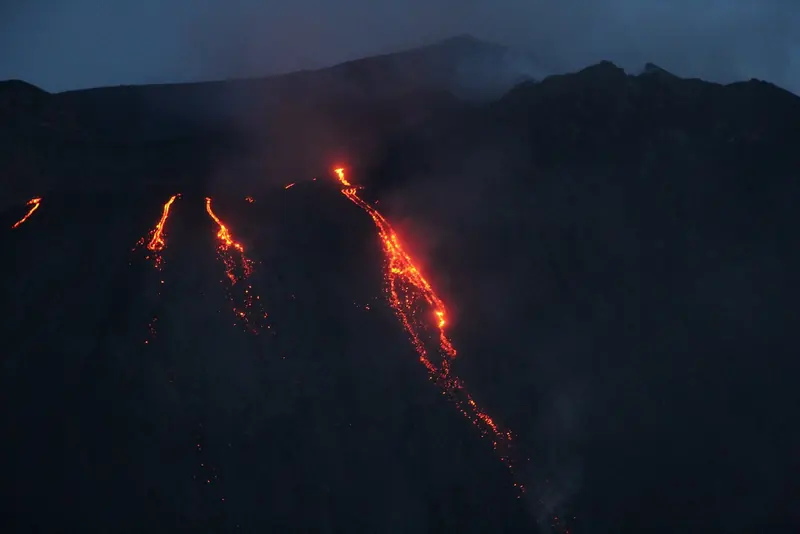 Stromboli in an effusive phase, lava running down the Sciara del Fuoco to the sea, which is what a yacht lies off to watch at night.