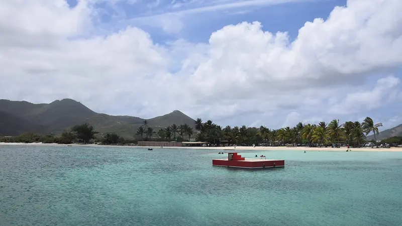 The turquoise shallows of Galion Bay on Saint-Martin's Atlantic coast, a sheltered swimming beach backed by hills on the French side of the island.