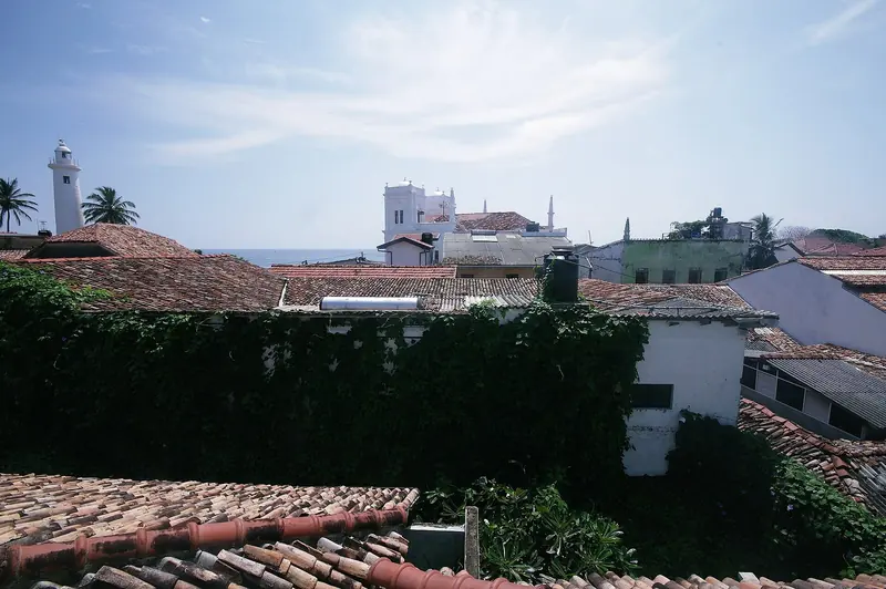 Galle Fort's lighthouse and the domed Meeran Jumma Mosque rise above the old town's tiled roofs, the skyline crews see from the anchorage waiting for Navy clearance.