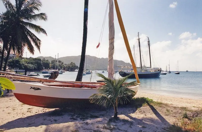 Admiralty Bay on Bequia holds a schooner and a spread of yachts at anchor, a locally built double ender hauled up on the sand under the palms.