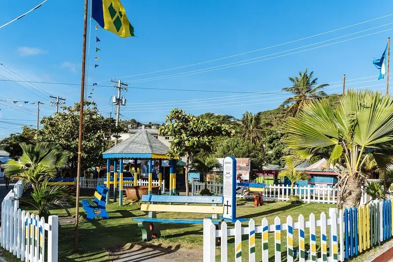 Painted benches and the national flag mark the small memorial garden in Clifton, with shops and bars lining the road behind.
