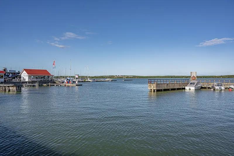 A red-roofed harbour building and moored boats at Mariehamn's Osterhamn (East Harbour), Aland Islands.