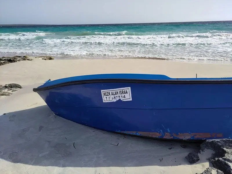 A wooden boat on the sand at Formentera, the shallow water that draws the fleet south.